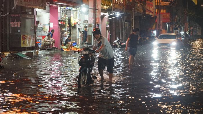 Nhiều phương tiện bị chết máy khi qua vùng ngập sâu trên đường Đoàn Trần Nghiệp. Ảnh: DUY TRẦN