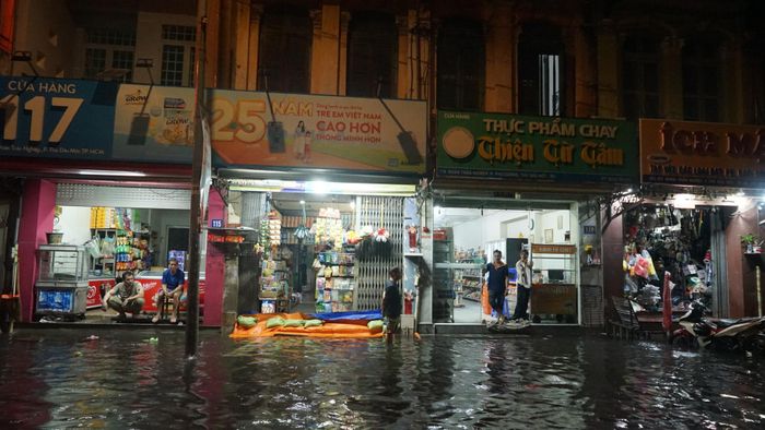 Nước tràn vào nhà và nhiều cửa hàng của tiểu thương chợ Thủ Dầu Một. Ảnh: DUY TRẦN