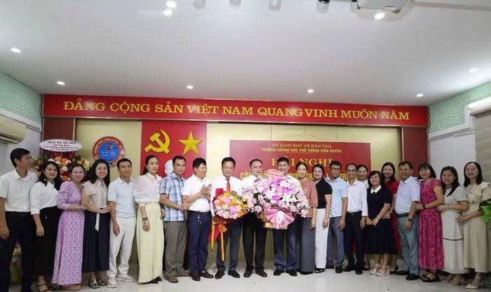 Cán bộ, giáo viên, nhân viên các tổ Trường THPT Cẩm Bình tặng hoa tại buổi lễ công bố Quyết định nhận nhiệm vụ mới. (Ảnh: CTV)