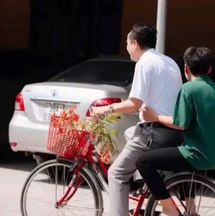 Hiệu trưởng Nguyễn Văn Quang giản dị, gần gũi chở học trò trên chiếc xe đạp trong sân trường. (Ảnh CTV)