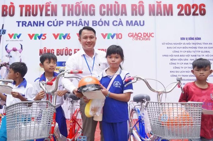 Nhà báo Nguyễn Xuân Lộc, phụ trách Văn phòng đại diện Báo Giáo dục và Thời đại tại ĐBSCL, trao xe đạp và quà cho các em học sinh. Ảnh: YP.