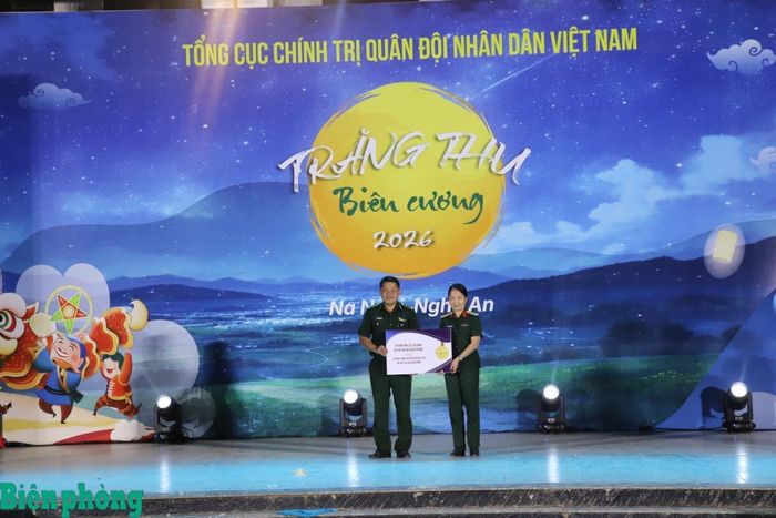 Đại tá Nguyễn Thúy Hòa, Chánh Văn phòng Ủy ban Dân số, Gia đình và Trẻ em, Bộ Quốc phòng trao biểu trưng tặng kinh phí học tập tặng 15 cháu là con của cán bộ các đơn vị đang công tác trên địa bàn xã Na Ngoi. Ảnh: Viết Lam