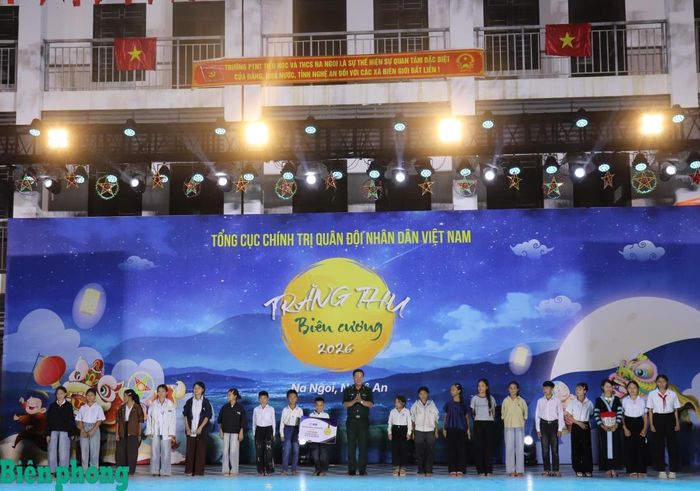 Thiếu tướng Văn Ngọc Quế trao biển tượng trưng tặng 20 suất học bổng cho các em học sinh. Ảnh: Viết Lam