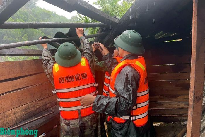 Cán bộ, chiến sĩ Đồn Biên phòng cửa khẩu A Đớt hỗ trợ gia đình ông Pơ Loong Thuốc ở thôn A Đớt di dời đồ đạc đến nơi an toàn do sạt lở. Ảnh: Võ Tiến