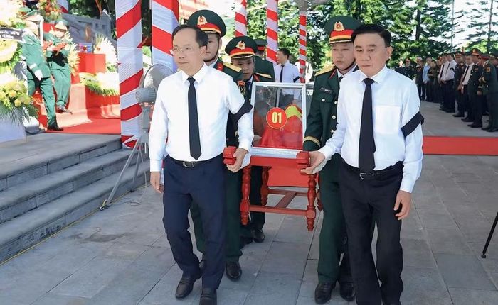  Thường trực Ban Bí thư Trần Cẩm Tú và Bí thư Tỉnh ủy Hà Tĩnh Nguyễn Duy Lâm thành kính đưa hài cốt các liệt sĩ về phần mộ, nơi các anh yên nghỉ trong lòng đất Mẹ. Ảnh: VĐ 