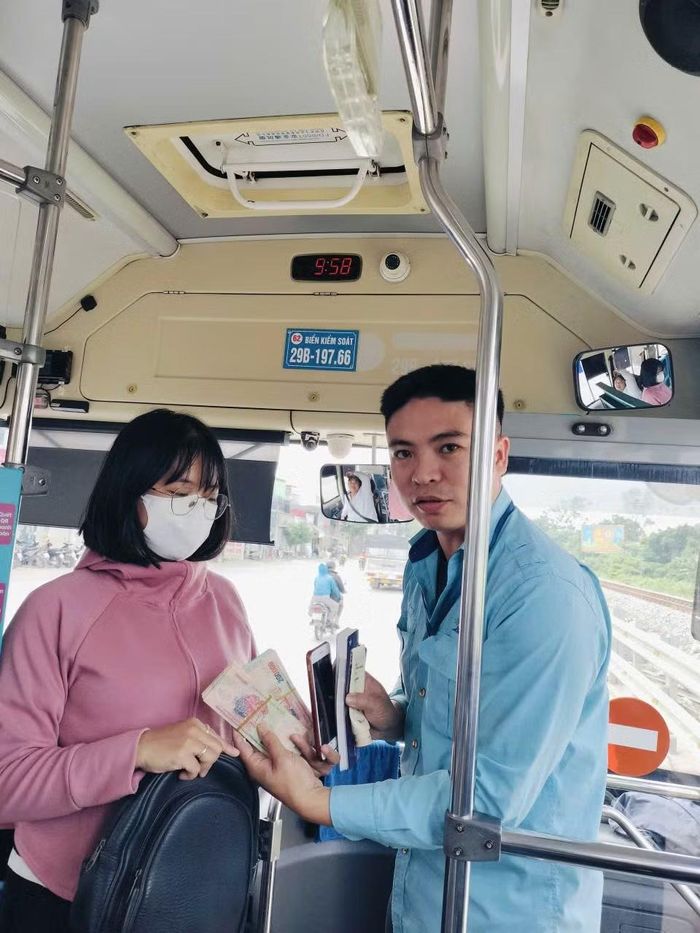 Nhân viên xe buýt trao trả tài sản cho hành khách bỏ quên. Ảnh: H.Giang