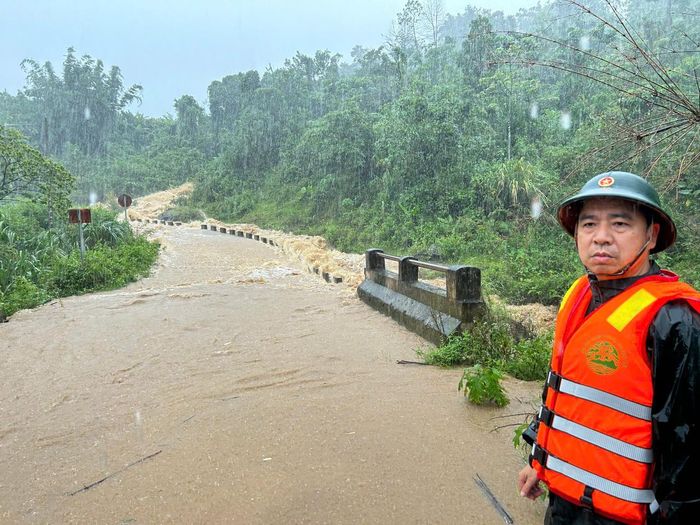 Nước lũ cuồn cuộn phủ kín mặt đường, mưa không ngừng tuôn. Cán bộ Biên phòng Quảng Trị bám chốt, cảnh giới, ngăn người dân và phương tiện đi vào khu vực nguy hiểm. (Ảnh: BĐBP Quảng Trị)