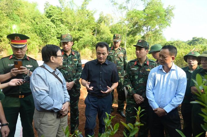 Ông Giàng Quốc Hưng (người mặc áo đen) - Phó Chủ tịch Ủy ban nhân dân tỉnh Lào Cai và Thượng tá Lương Hoàng Giang - Chính ủy Bộ Chỉ huy quân sự tỉnh trò chuyện với các cựu chiến binh và chỉ đạo công tác cất bốc hài cốt liệt sĩ. (Ảnh: Nguyễn Hải)