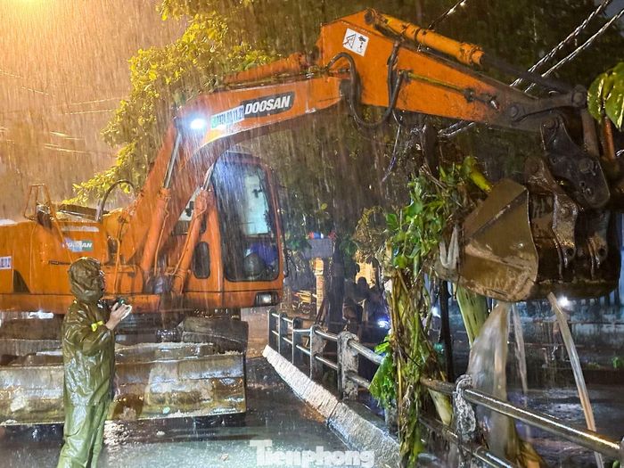 Cùng với công tác hỗ trợ di dời dân, lực lượng chức năng cũng khẩn trương khơi thông khu vực cầu trên tuyến đường Mẹ Suốt, nơi rác thải và vật cản bị nước cuốn về gây ùn ứ, ảnh hưởng đến khả năng thoát nước.