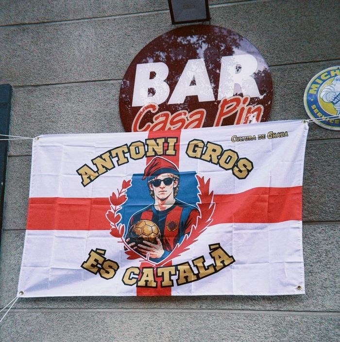  Quán Casa Pin gần sân Camp Nou treo một lá cờ Thánh George với ảnh Anthony Gordon đội chiếc mũ Catalonia truyền thống. 