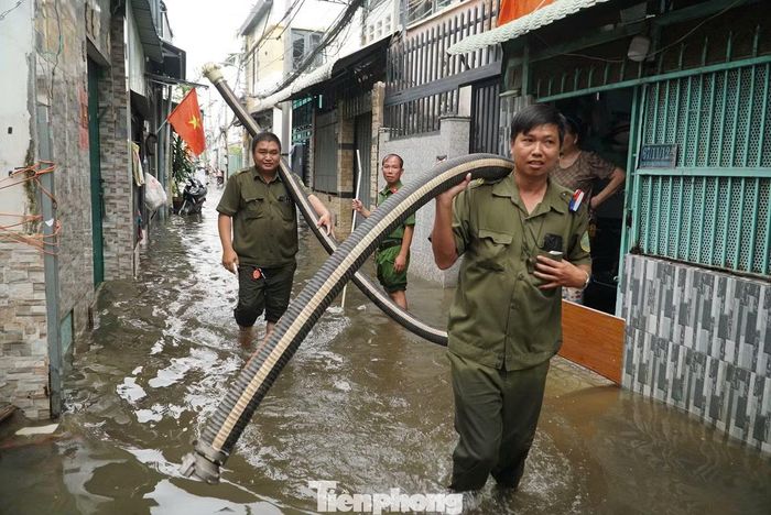 Lực lượng công an đồng thời huy động máy bơm đến các điểm ngập nặng, hỗ trợ người dân bơm nước ra khỏi nhà, hạn chế thiệt hại do ngập kéo dài. Ảnh: Nguyễn Tiến
