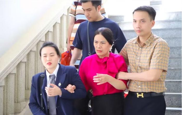 Cô Nguyễn Thị Bình cùng luật sư rời phiên tòa tạm nghỉ.