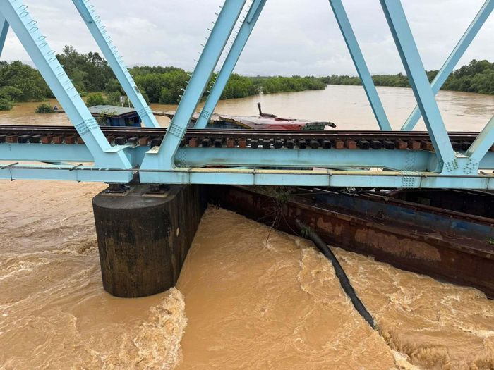 Xà lan bị nước lũ cuốn trôi, mắc kẹt dưới cầu đường sắt Mỹ Chánh, xã Nam Hải Lăng, tỉnh Quảng Trị. Ảnh: CTV