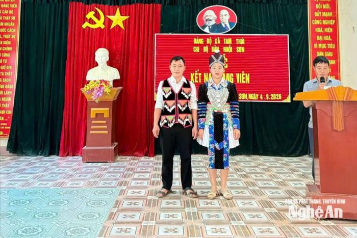 Vợ chồng Lầu Bá Mà, Lầu Y Sềnh nghiêm trang nghe Bí thư Chi bộ đọc Quyết định kết nạp Đảng viên. Ảnh: Khánh Nguyên