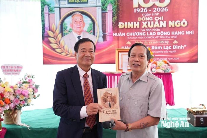Ông Nguyễn Trung Châu - nguyên Phó Chủ tịch UBND TP.Vinh, người đã tập hợp các tư liệu về ông Đinh Xuân Ngô và phối hợp với Nhà xuất bản Nghệ An, xuất bản cuốn sách "Người con xóm Lạc Đình", trao sách cho đại diện gia đình. Ảnh: Tiến Đông