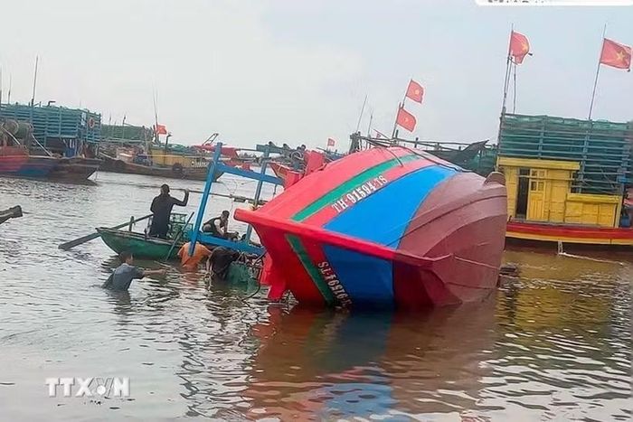 Tàu cá TH-91594-TS của ông Cao Văn Chung (sinh năm 1977) trú tại tổ dân phố Đồng Minh, phường Ngọc Sơn trong thời gian neo đậu tại khu vực Lạch Ghép, thuộc tổ dân phố Đồng Minh thì bất ngờ bị chìm. (Ảnh: TTXVN phát)