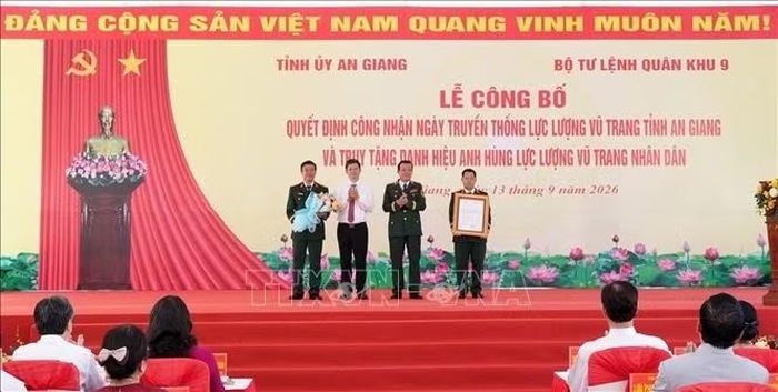 Trung Tướng Hồ Văn Thái, Bí thư Đảng ủy, Chính ủy Quân khu 9 và đồng chí Lê Quang Tùng, Ủy viên BCH Trung ương Đảng, Bí thư Tỉnh ủy tỉnh An Giang trao Quyết định công nhận ngày truyền thống lực lượng vũ trang tỉnh An Giang và tặng hoa chúc mừng. Ảnh: Lê Huy Hải/TTXVN