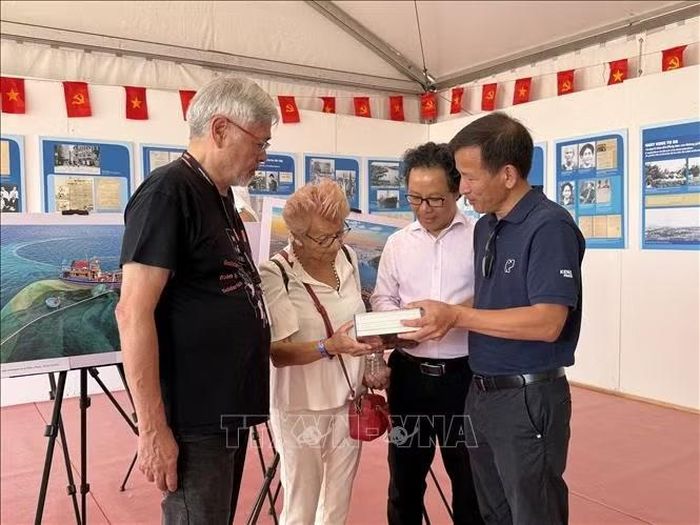 Đại diện Báo Nhân Dân giới thiệu các ấn phẩm với bà Hélène Luc, Thượng nghị sỹ danh dự và là Chủ tịch danh dự Hội hữu nghị Pháp - Việt. Ảnh: Hữu Chiến/PV TTXVN tại Pháp