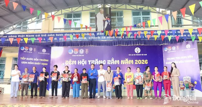 Ban Tổ chức trao quà cho các hộ gia đình chính sách, hộ có hoàn cảnh khó khăn. Ảnh: Ngọc Huyền