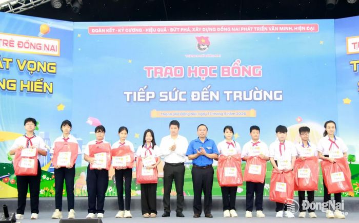 Đại diện Thành đoàn, Sở Giáo dục và Đào tạo trao học bổng cho các em học sinh vượt khó học tốt. Ảnh: Nga Sơn