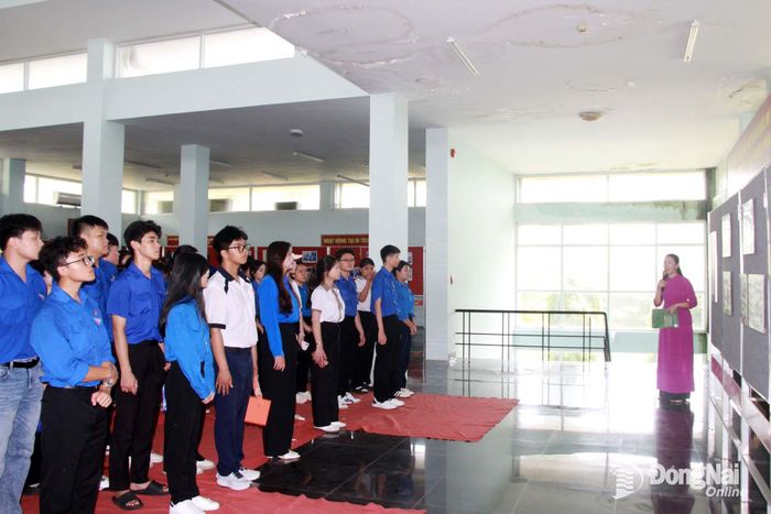 Các đại biểu nghe thuyết minh tại Di tích Nhà lao Tân Hiệp. Ảnh: Nga Sơn