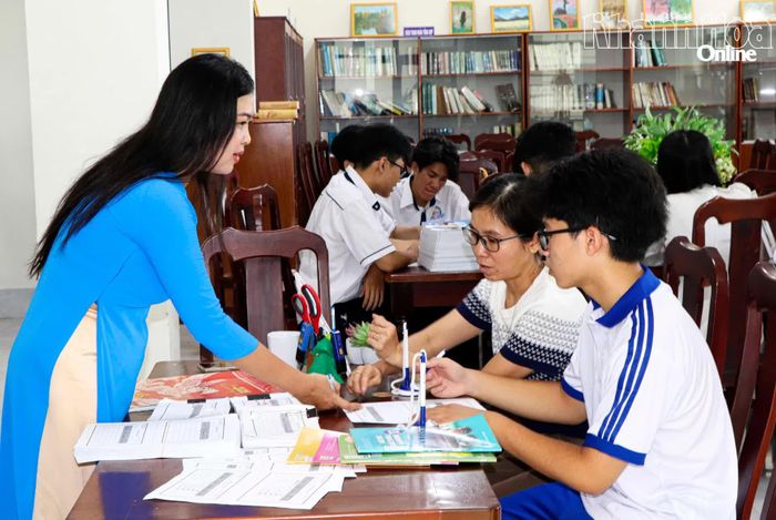 Phụ huynh và học sinh lớp 10 làm thủ tục mượn sách giáo khoa tại Thư viện Trường THPT Nguyễn Trãi - Phan Rang.