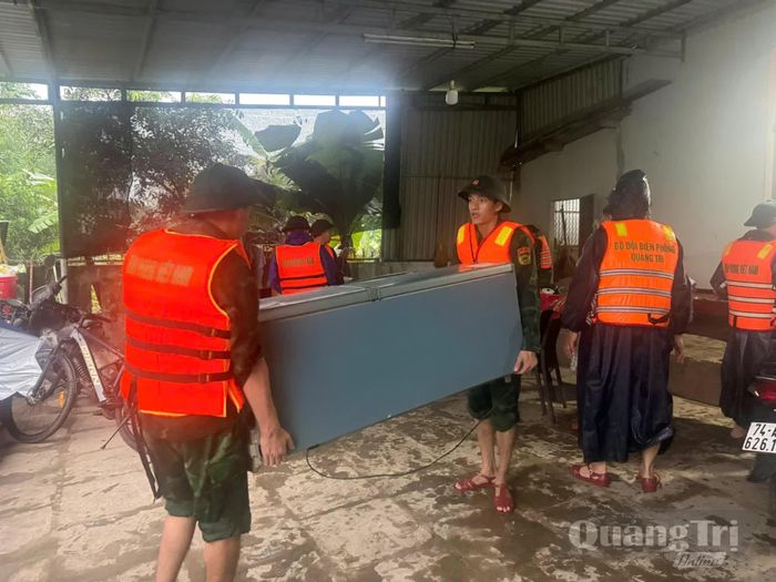 Cán bộ, chiến sĩ Đồn Biên phòng cửa khẩu quốc tế Lao Bảo giúp dân di dời tài sản đến nơi an toàn - Ảnh: P.K