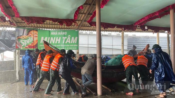 Chính quyền địa phương huy động lực lượng hỗ trợ di dời tàu, thuyền của ngư dân ra khỏi khu vực bãi tắm Mỹ Thủy - Ảnh: Đồn Biên phòng Hải An
