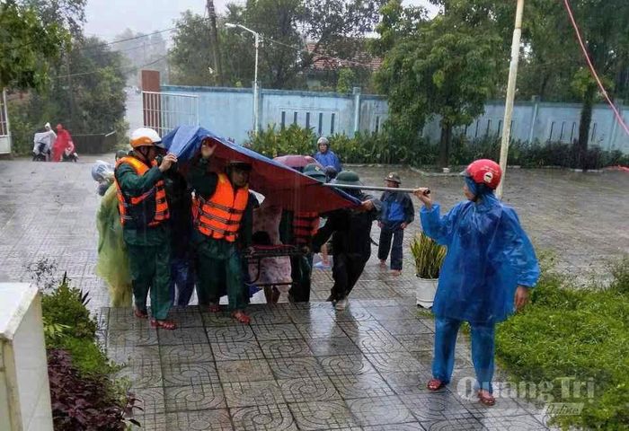 Lực lượng chức năng di dời người dân đến nơi an toàn - Ảnh: Q.D