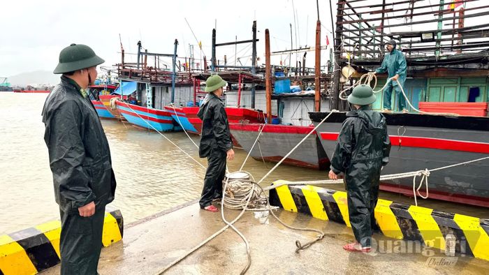 Cán bộ Đồn Biên phòng cửa khẩu Cảng Gianh kiểm tra, hướng dẫn ngư dân neo buộc tàu cá - Ảnh: Quang Ngọc