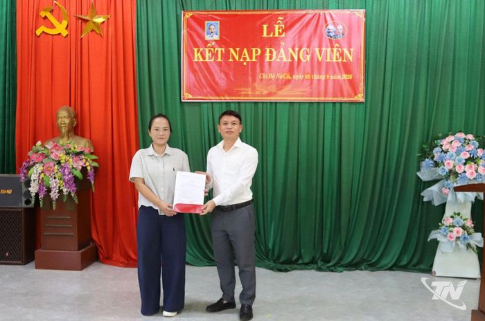 Đồng chí Nguyễn Thành Trung, Ủy viên Ban Thường vụ Đảng ủy, Phó Chủ tịch UBND xã Cẩm Giàng, trao quyết định kết nạp Đảng cho đảng viên Hoàng Thị Duyên, Chi bộ Nà Cù.
