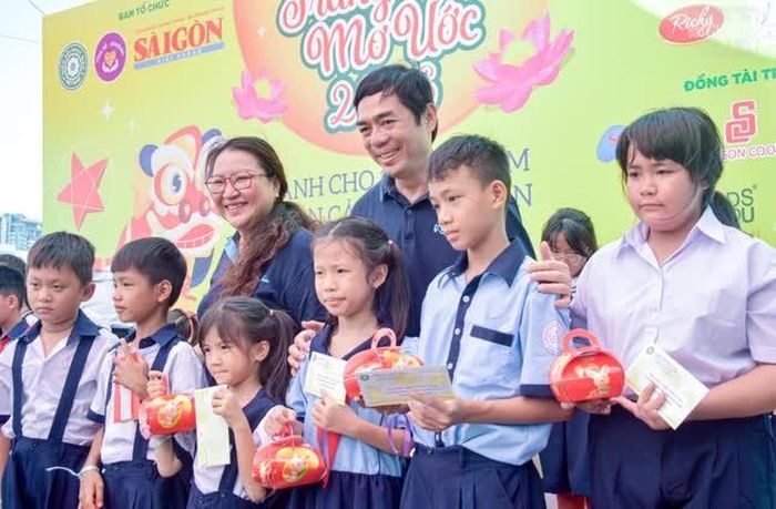 Ông Nguyễn Khắc Cường, bà Trần Gia Bảo, đồng Phó Tổng Biên tập Báo Sài Gòn Giải Phóng trao quà trung thu đến các em học sinh