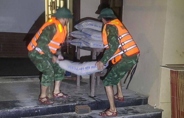 Lực lượng chức năng hỗ trợ người dân di dời đồ đạc trong đêm tại xã Lao Bảo.