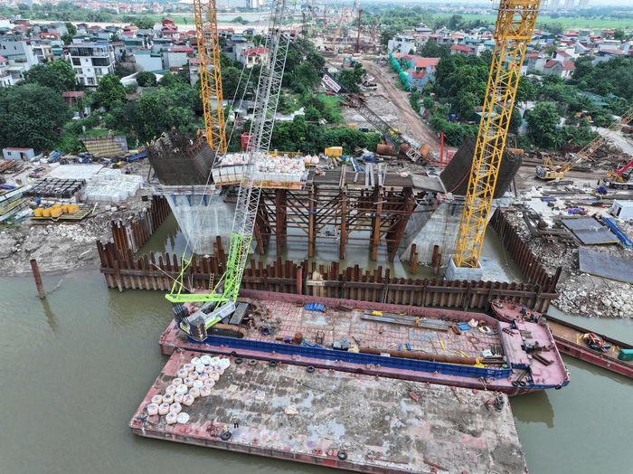 Chỉ sau hơn một năm, toàn bộ khoảng 63ha mặt bằng theo chỉ giới dự án đã được tiếp nhận. Tại cầu chính, toàn bộ 84 cọc khoan nhồi của hai trụ tháp P37, P38 cùng 2 bệ trụ đã hoàn thành. Đơn vị thi công đang tiếp tục xây dựng các đốt thân tháp và dầm ngang. Tại nút giao Nghi Tàm, 156/167 cọc và 11/23 bệ trụ đã hoàn thành. Nút giao Trường Sa hoàn thành 121/346 cọc và 6/27 đốt hầm hở thuộc hầm chui Quốc lộ 5. Cầu dẫn phía Nghi Tàm đạt 362/642 cọc khoan nhồi, trong khi cầu dẫn phía Đông Anh hoàn thành 144/208 cọc.