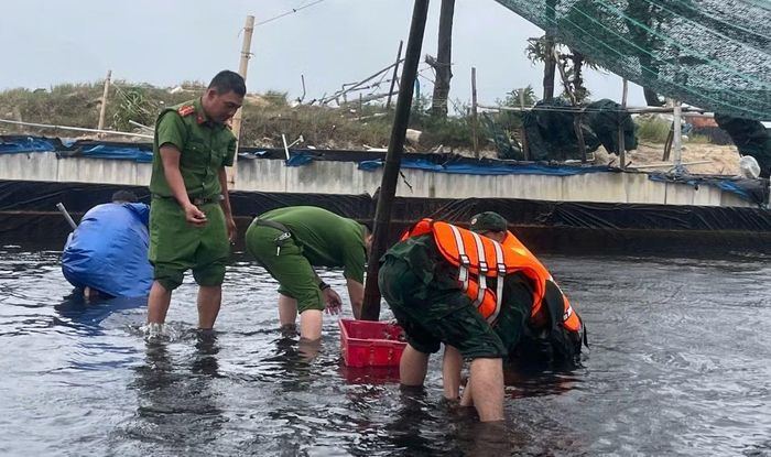 Công an xã Mỹ Thuỷ hỗ trợ người dân thu gom ốc hương khi mưa lớn gây ngập.