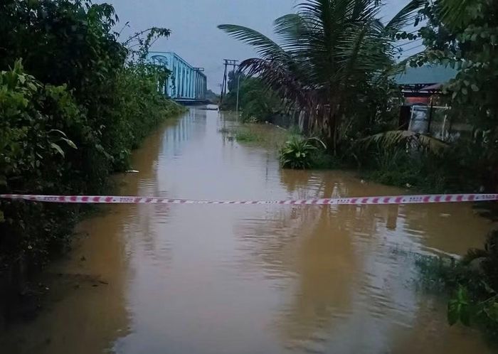 Công an xã Hưng Lộc vào vùng ngập lụt giúp dân và căng dây cảnh báo các đoạn ngập sâu.