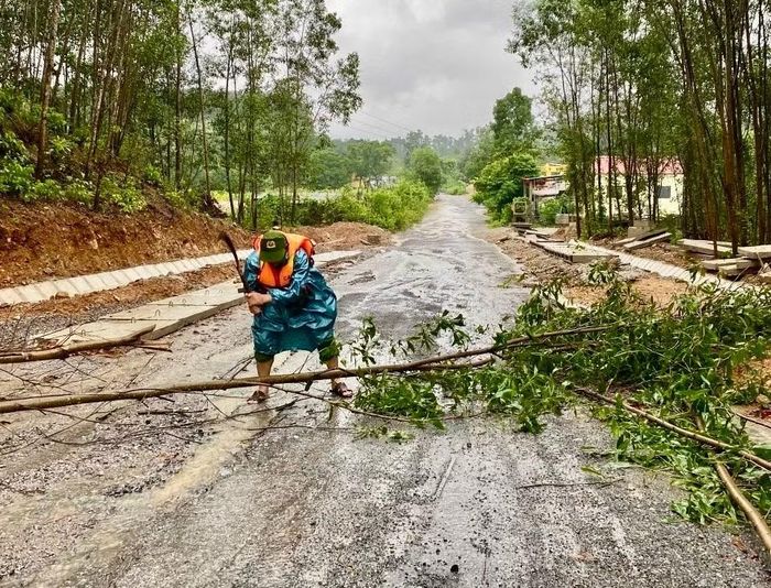 Công an xã Kim Ngân chặt cây cối bị đổ ngã do mưa lũ, đảm bảo giao thông được thông suốt.
