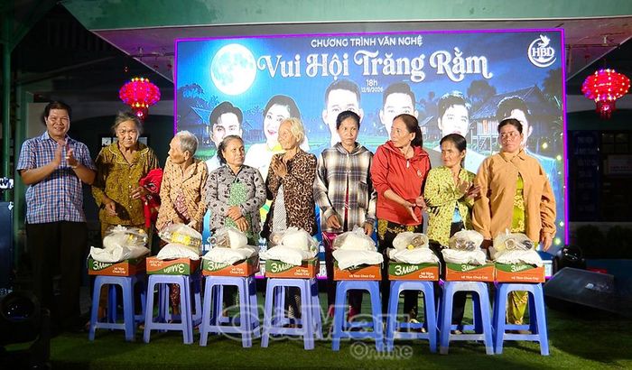 Bí thư Đảng uỷ phường Hiệp Thành Trần Minh Hải (bìa trái) trao các suất quà hỗ trợ người dân có hoàn cảnh khó khăn trong chương trình văn nghệ “Vui hội trăng rằm”.