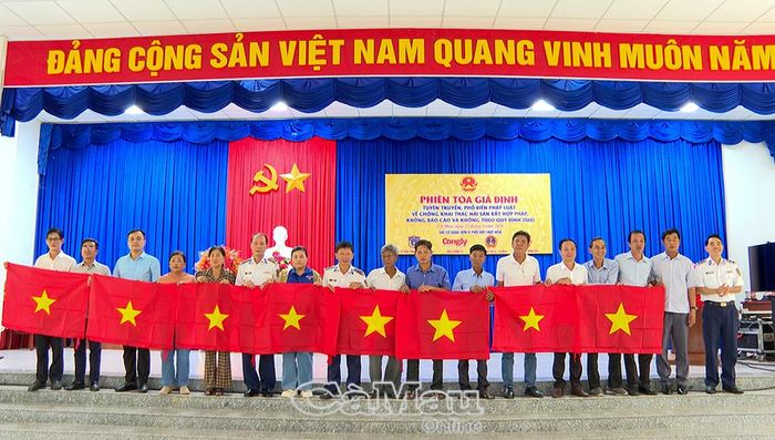 Đại diện Bộ Tư lệnh Vùng Cảnh sát biển 4 tặng cờ Tổ quốc cho ngư dân.