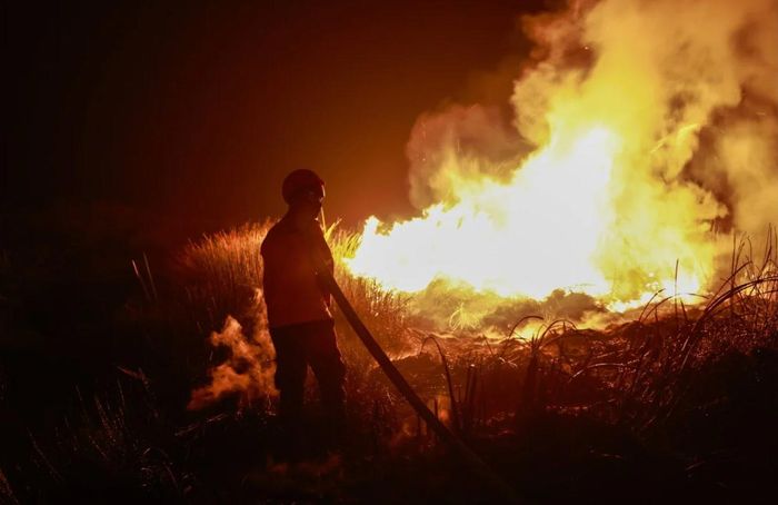 Lính cứu hỏa phun nước dập tắt đám cháy rừng ở Nam Sumatra, Indonesia, ngày 5/9. (Ảnh: EPA)