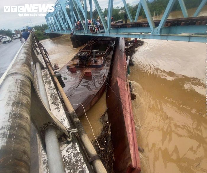 Cùng ngày, 3 sà lan hút cát (mỗi chiếc dài khoảng 30m) bị lũ cuốn trôi tự do từ thượng nguồn sông Ô Giang (hoặc sông Thác Ma) và va vào cầu đường sắt Mỹ Chánh (xã Nam Hải Lăng). Sau va chạm, 01 sà lan mắc kẹt tại khu vực giữa cầu đường sắt Mỹ Chánh và cầu đường bộ trên Quốc lộ 1; 02 sà lan còn lại mắc tại khu vực chân cầu và bị chìm một phần. Thời điểm xảy ra sự cố không có người trên các sà lan. (Ảnh: Trần Minh Hạnh)