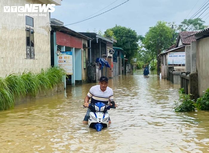 Nước lũ tại nhiều tuyến đường ở thôn Câu Hà (xã Nam Hải Lăng) ngập sâu, khiến nhiều xe máy chết máy, người dân phải dắt bộ về nhà. (Ảnh: Ánh Hằng)
