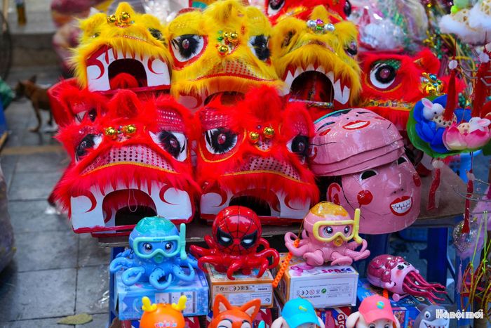 Hai bên đường, nhiều gian hàng bày bán các loại đồ chơi dân gian như đèn ông sao, đèn cá chép, ông tiến sĩ giấy, mặt nạ giấy bồi, tò he, đầu sư tử... Năm nay, nhiều phụ huynh có xu hướng tìm mua các sản phẩm này, giúp con trẻ biết đến Tết Trung thu truyền thống.