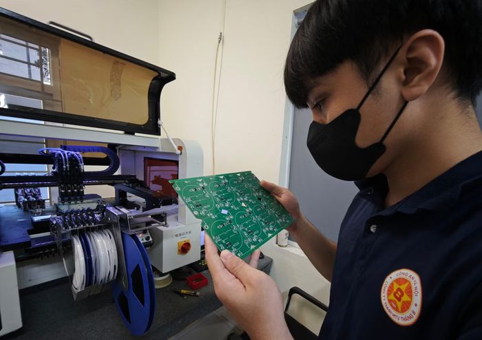 Kỹ thuật viên kiểm tra bản mạch điện tử sau công đoạn dán linh kiện tự động trên dây chuyền công nghệ cao