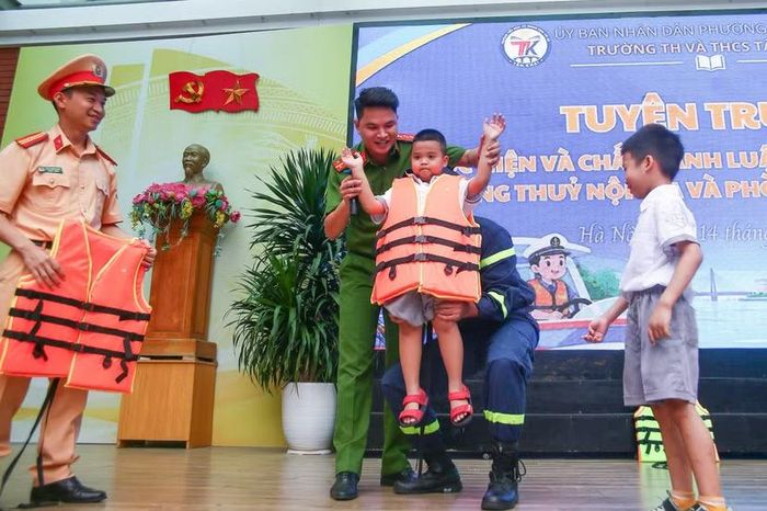 Cảnh sát hướng dẫn các em mặc áo phao.