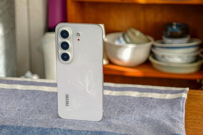  Điểm nhấn trên mặt lưng của Bezelless đến từ đèn LED thông báo màu đỏ cùng họa tiết cánh bướm 3D. Thiết kế này gợi nhớ đến những ý tưởng mà Tecno từng mang đến triển lãm MWC hồi đầu năm, gồm điện thoại với mặt lưng E-Ink đổi màu, hoặc tích hợp nam châm để gắn thêm phụ kiện. Ảnh: The Verge. 