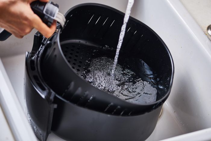  Vệ sinh nồi chiên không dầu thường xuyên giúp loại bỏ cặn thức ăn, dầu mỡ tích tụ và hạn chế chúng tiếp tục bị nung nóng trong những lần sử dụng sau. Ảnh: Uber Appliance.
