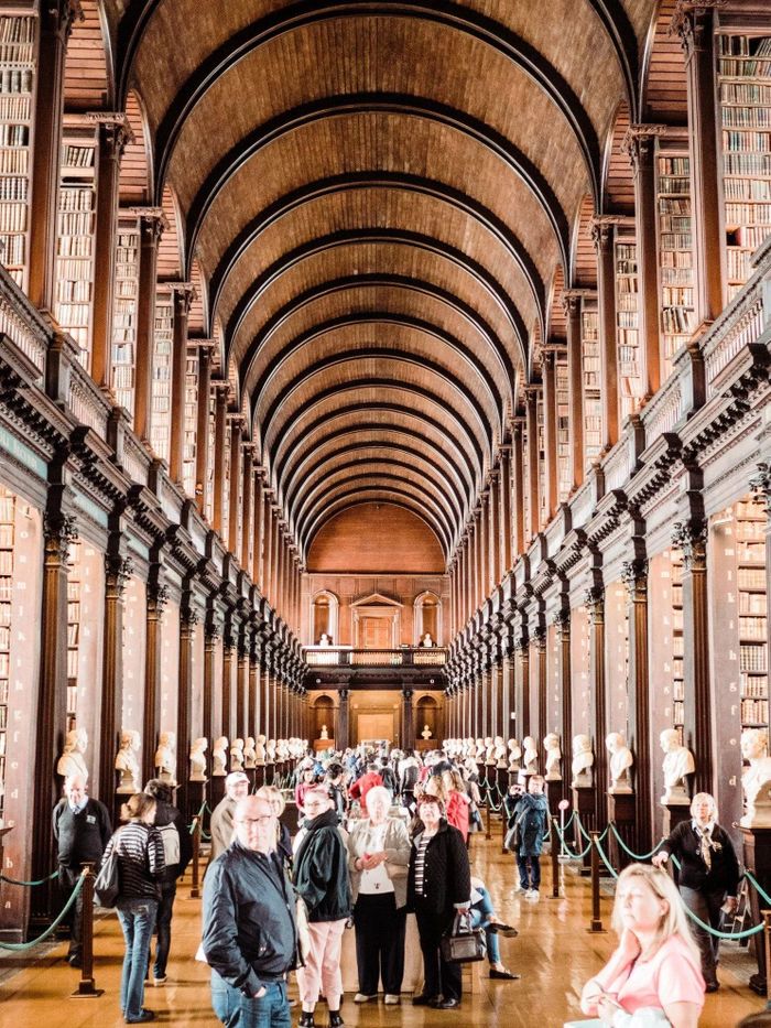 Điểm gây ấn tượng nhất của Old Library là Long Room - đại sảnh dài gần 65 m nằm ở trung tâm tòa nhà. Không gian này được bao quanh bởi những giá sách gỗ sẫm màu, các cột mang phong cách Corinth và hệ thống ban công chạy dọc hai bên. Phía trên là trần gỗ hình vòm, tạo cảm giác như một thánh đường dành cho sách. Khi được xây dựng, Long Room từng có trần phẳng bằng thạch cao và chỉ có giá sách ở tầng dưới, nhưng đến thế kỷ 19, công trình được cải tạo, nâng mái và bổ sung trần vòm cùng hệ thống giá sách tầng trên. Ảnh: Trinity College Dublin.