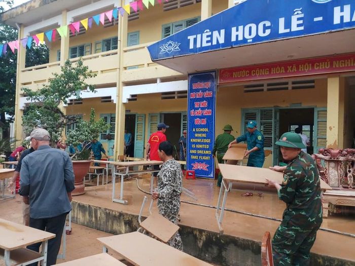 Lực lượng BĐBP chung tay dọn dẹp bùn đất, vệ sinh trường lớp sau lũ. Ảnh: TG