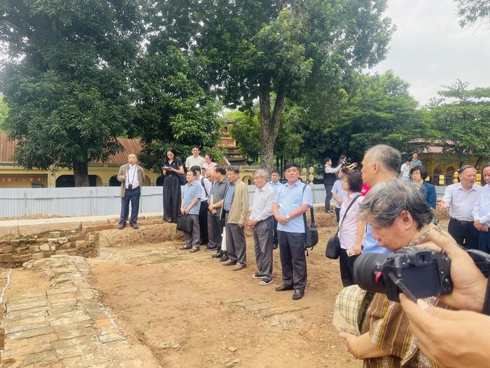 Các chuyên gia, nhà nghiên cứu và đại biểu trực tiếp tìm hiểu hiện trường khai quật khu vực chính điện Kính Thiên năm 2026 tại hố khai quật khảo cổ số 9 Hoàng Diệu. Ảnh: Tuyết Mai - TTXVN